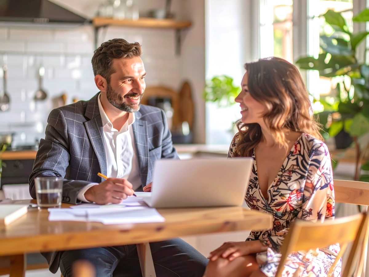 Two people talking through a home's priorities at a kitchen table.